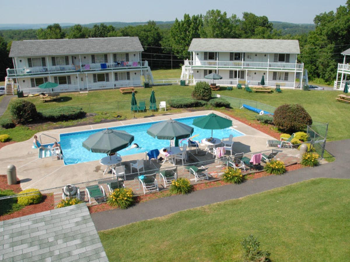 Aerial view of the heated outdoor pool, sun umbrellas and guest buildings at Gavin's Irish Country Inn in the Catskills