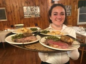 A Gavin's server carrying plates of prime rib in the dining room