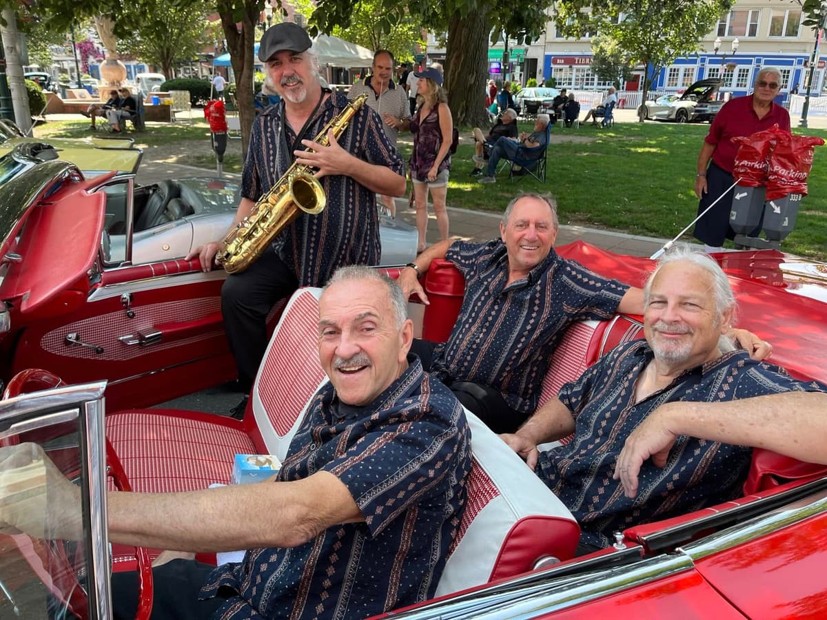 Roadhouse, the Hudson Valley 60s dance band, posing in a vintage red convertible