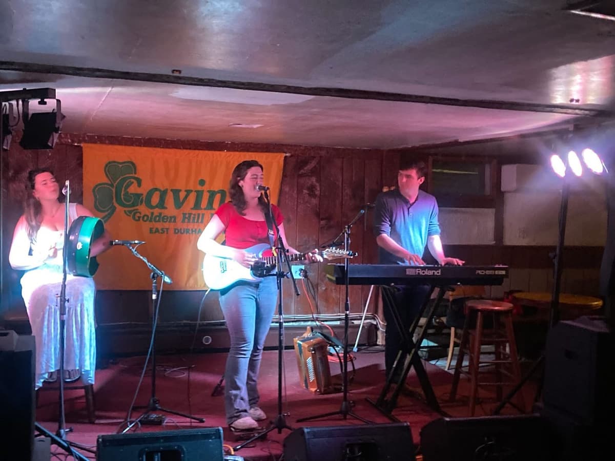 A three-piece band performing on the Golden Hill Pub stage at Gavin's