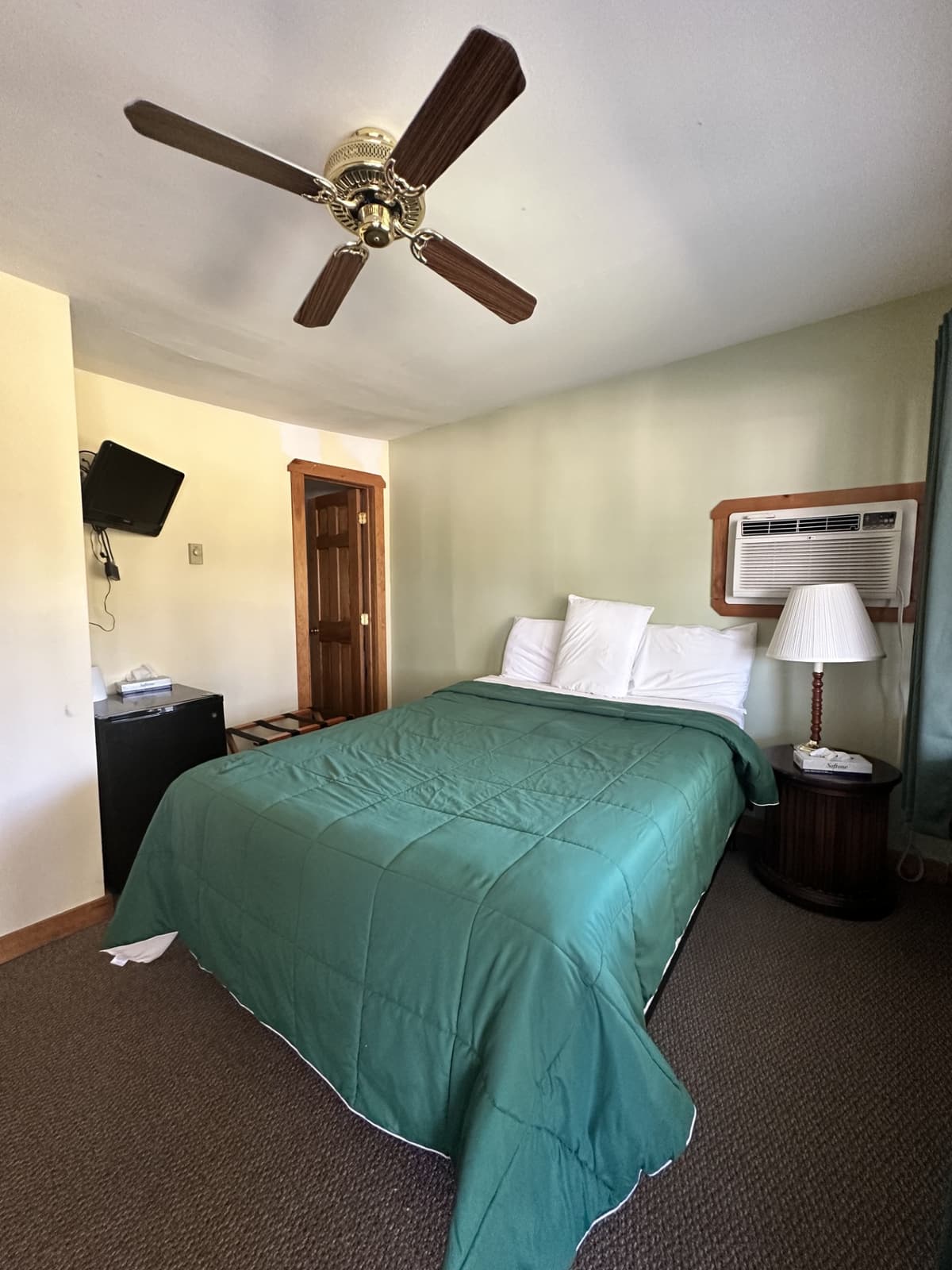 Second cottage bedroom with a queen bed and ceiling fan