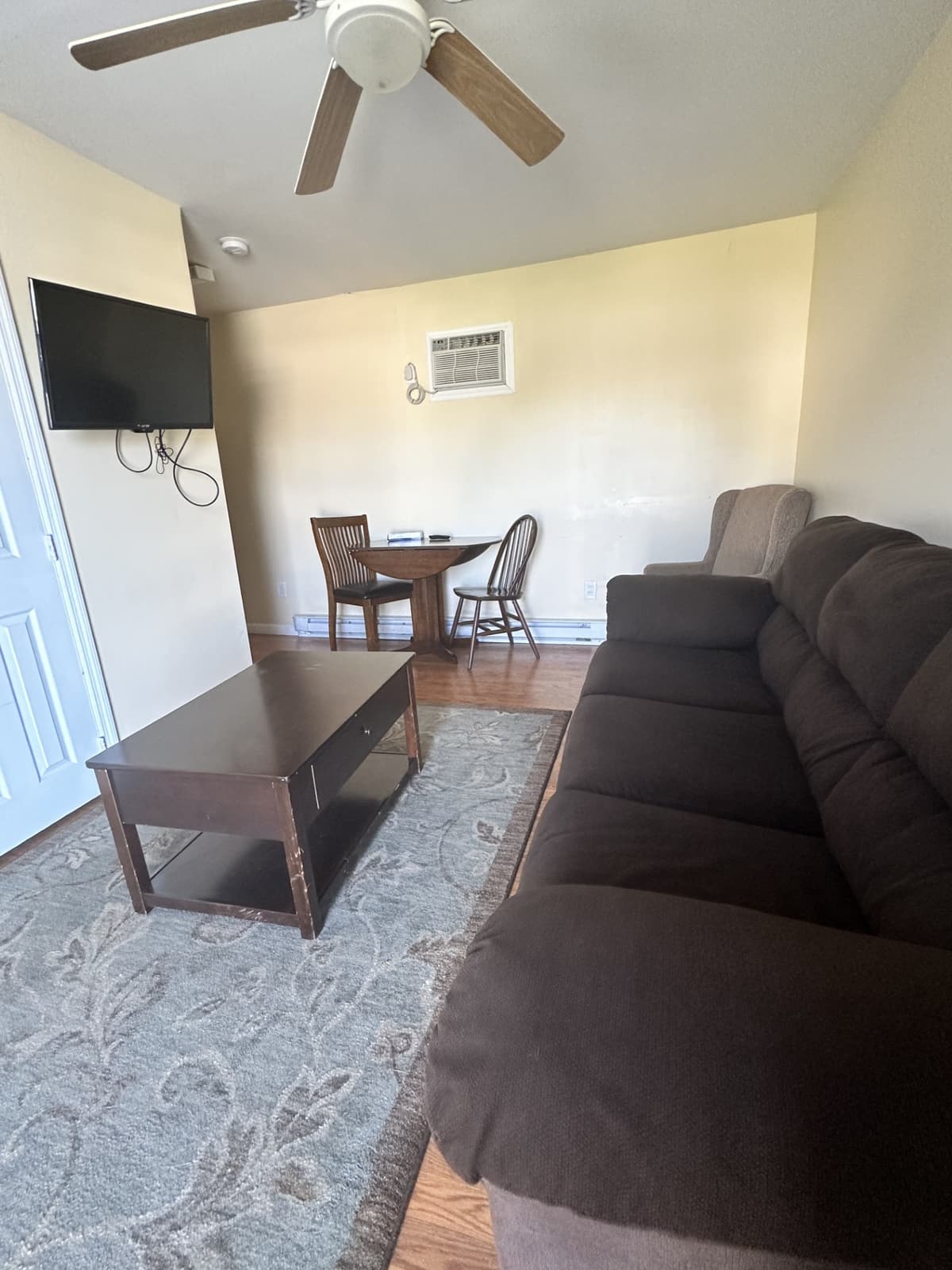 Living room with sofa and French doors in a 2024 poolside suite