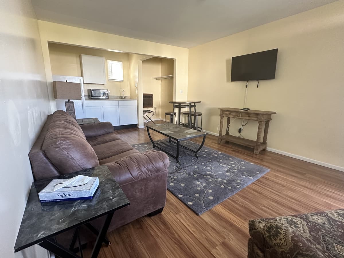 Poolside suite living area with leather sofa, TV and kitchenette