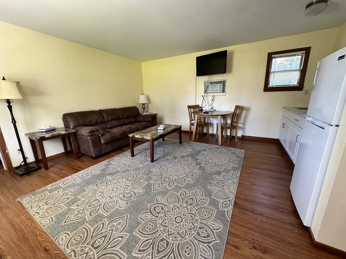 Large living room with sofa, dining table and kitchenette in a two-bedroom suite
